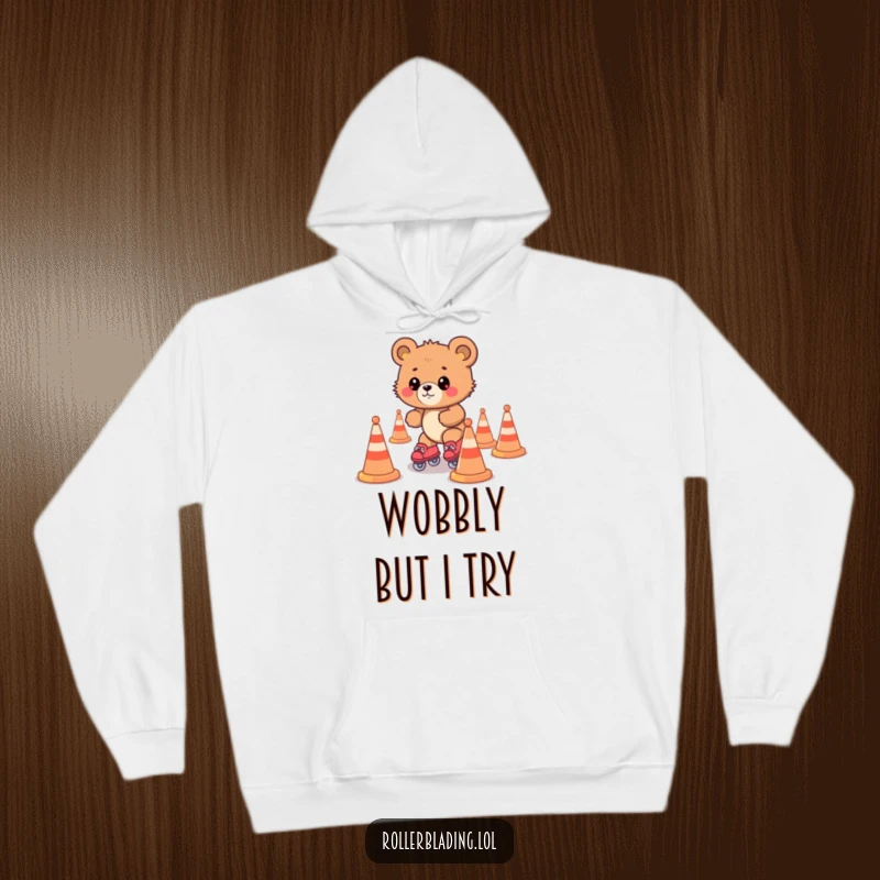Funny bear cub struggling on roller skates amidst cones, a cozy and humorous hoodie design for ultimate comfort.
